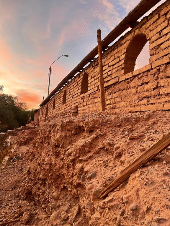 a brick wall on top of a dirt hill at Cabañas San Pedro de Atacama. in San Pedro de Atacama