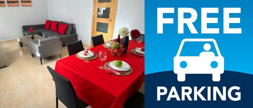 una habitación con una mesa con un mantel rojo y una habitación con coche en Calle Mora De Rubielos with Free Private Underground Parking, en Valencia