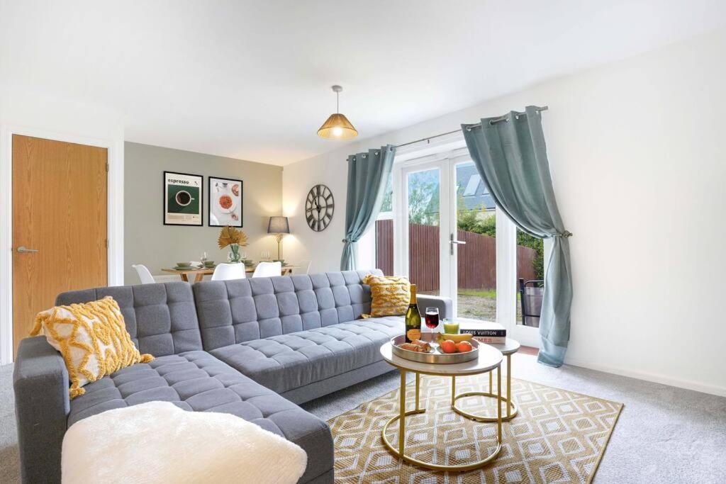 a living room with a blue couch and a table at Appledore House - Close to City Centre - Free Parking, Fast Wifi, Private Garden and Smart TV with Netflix by Yoko Property in Milton Keynes
