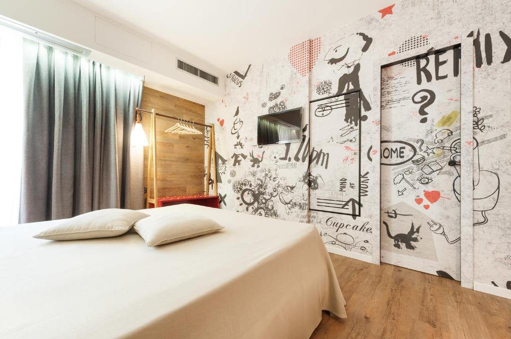 een slaapkamer met een bed en een muur bedekt met graffiti bij Hotel La Pergola in Grezzana