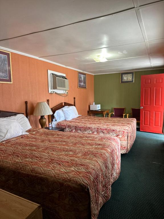 a hotel room with two beds and a red door at Sands Motel in Marianna