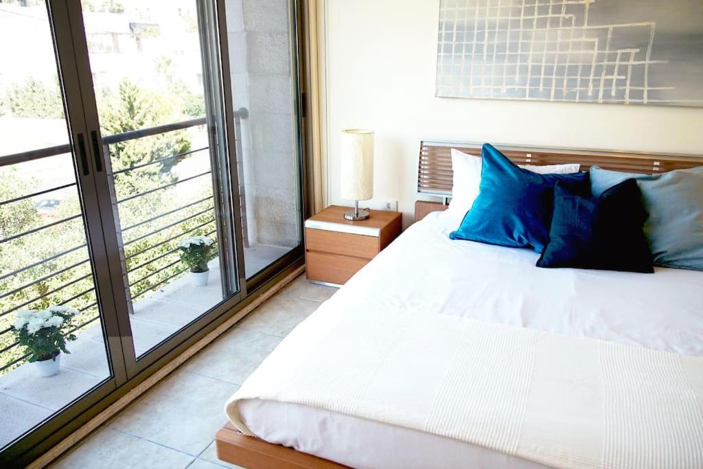 A bed or beds in a room at Sleek & Cozy Apartment with Pool & Patio In Abdoun
