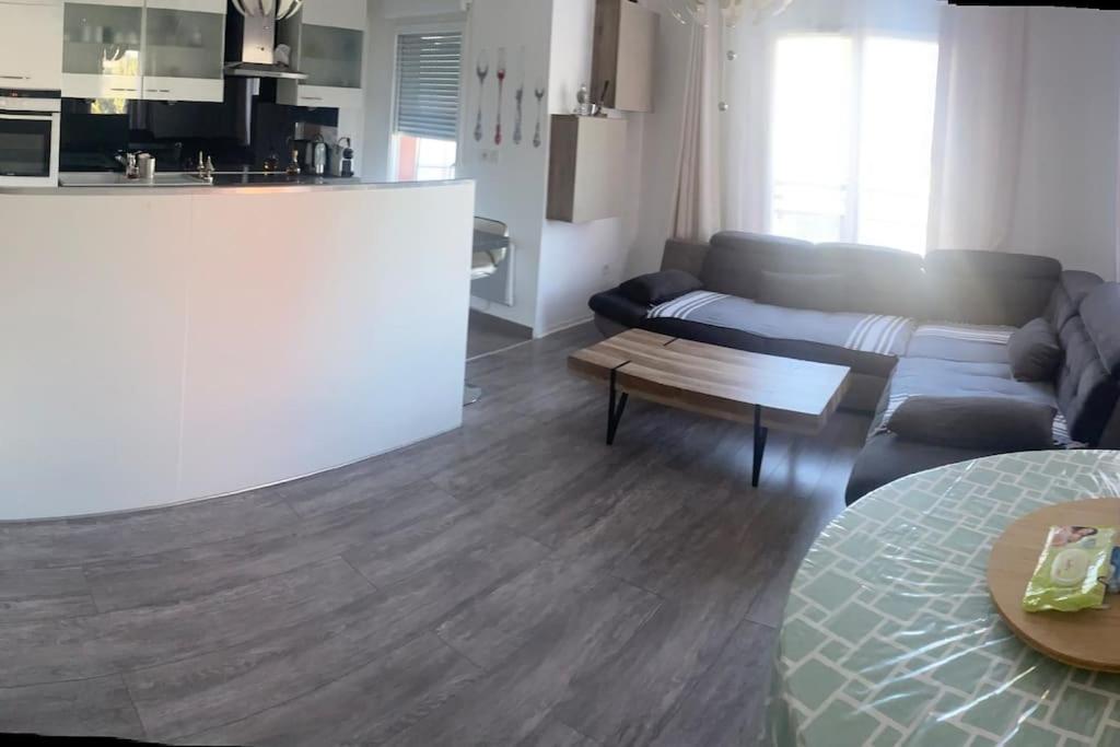 een woonkamer met een bank en een tafel bij Appartement Aéroport Orly in Athis-Mons