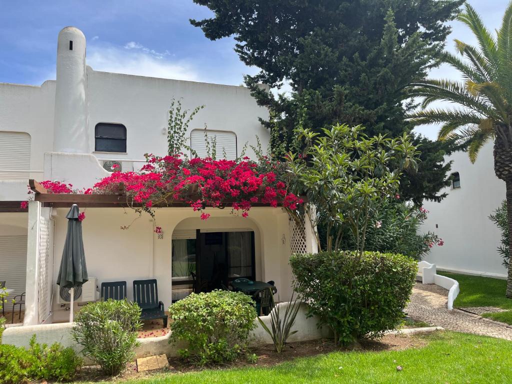 Casa blanca con balcón con flores rosas en Beautiful Villa with terrace & garden, en Ferragudo