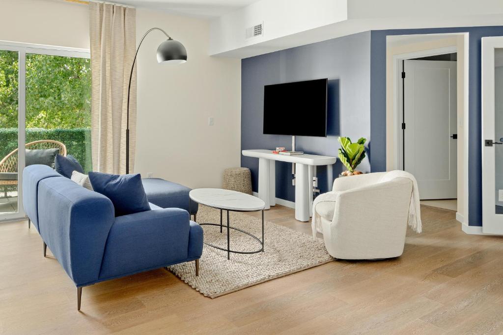 uma sala de estar com um sofá azul e uma televisão em Heart of Olde Town - Urban Retreat - 95 Walk Score em Arvada