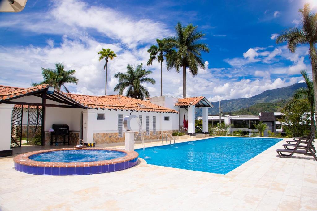 a swimming pool in front of a house with palm trees at Espectacular Villa en Copacabana in Copacabana
