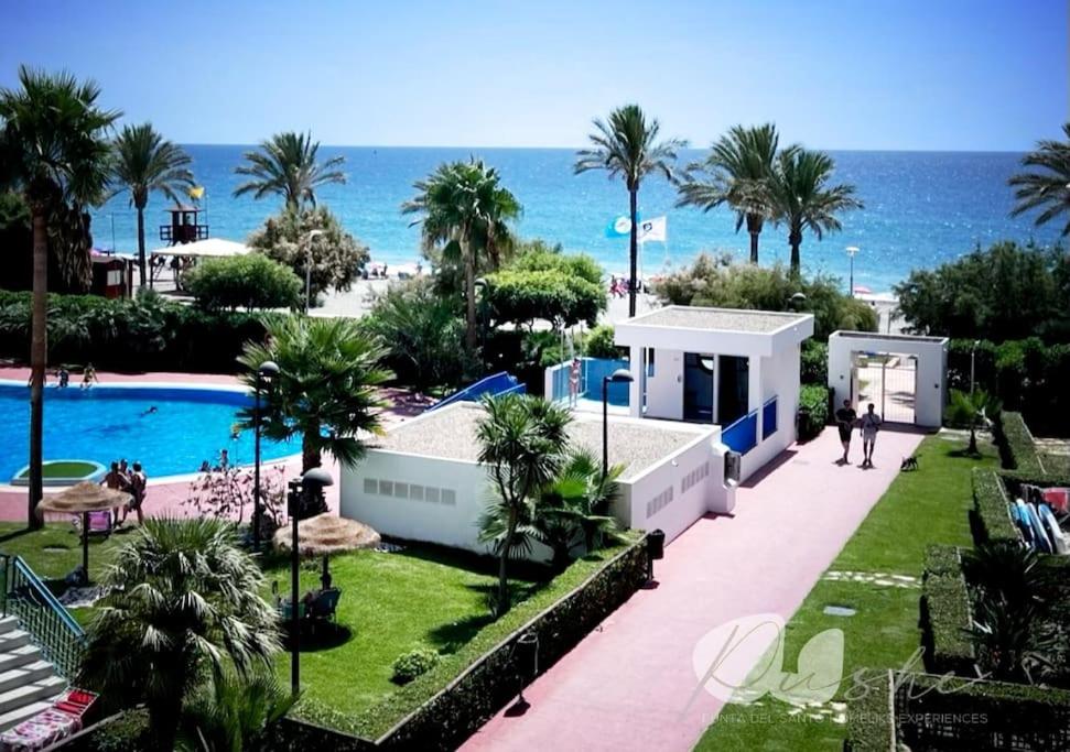 カステル・デ・フェロにあるPUSHE Castell de Ferro Beach & Tradition 2のスイミングプールとビーチのあるリゾートの景色を望めます。