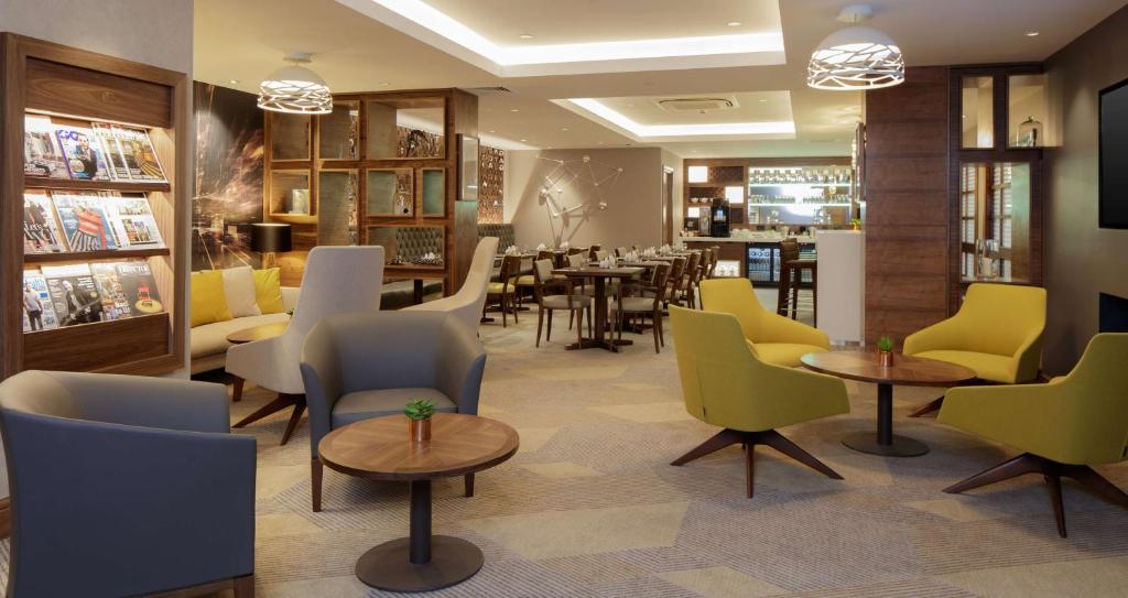 um restaurante com cadeiras e mesas e uma sala de jantar em Hilton Cambridge City Centre em Cambridge