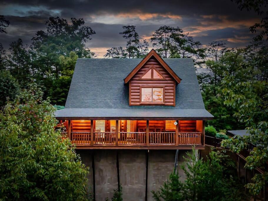 a log home with a wrap around porch and a deck at Cabin-n-Smokys! Indoor Resort Pool Views Hot Tub Game Room in Sevierville