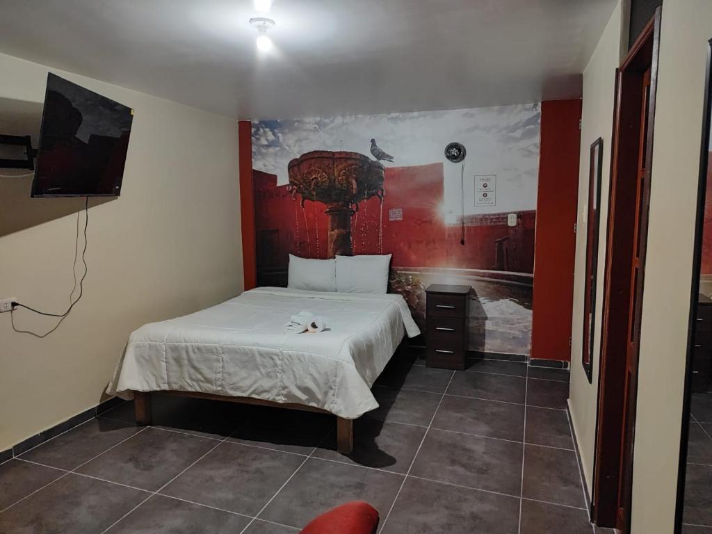 - une chambre avec un lit et un mur rouge dans l'établissement Sillary Sede Paucarpata, à Paucarpata