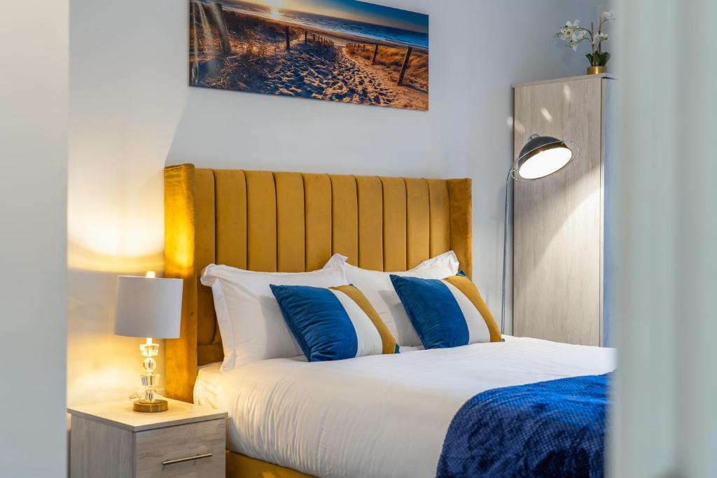 a bedroom with a bed with blue and white pillows at Birmingham City Center - Luxury Stay 86 in Birmingham