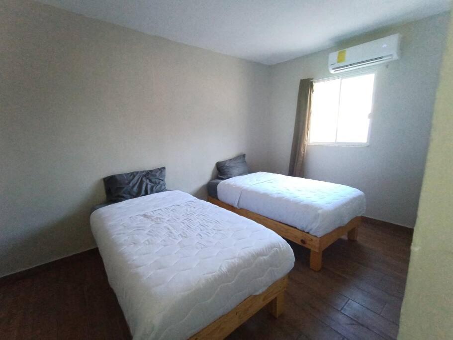 ein kleines Zimmer mit 2 Betten und einem Fenster in der Unterkunft Casa Villa (facturamos) in Los Mochis