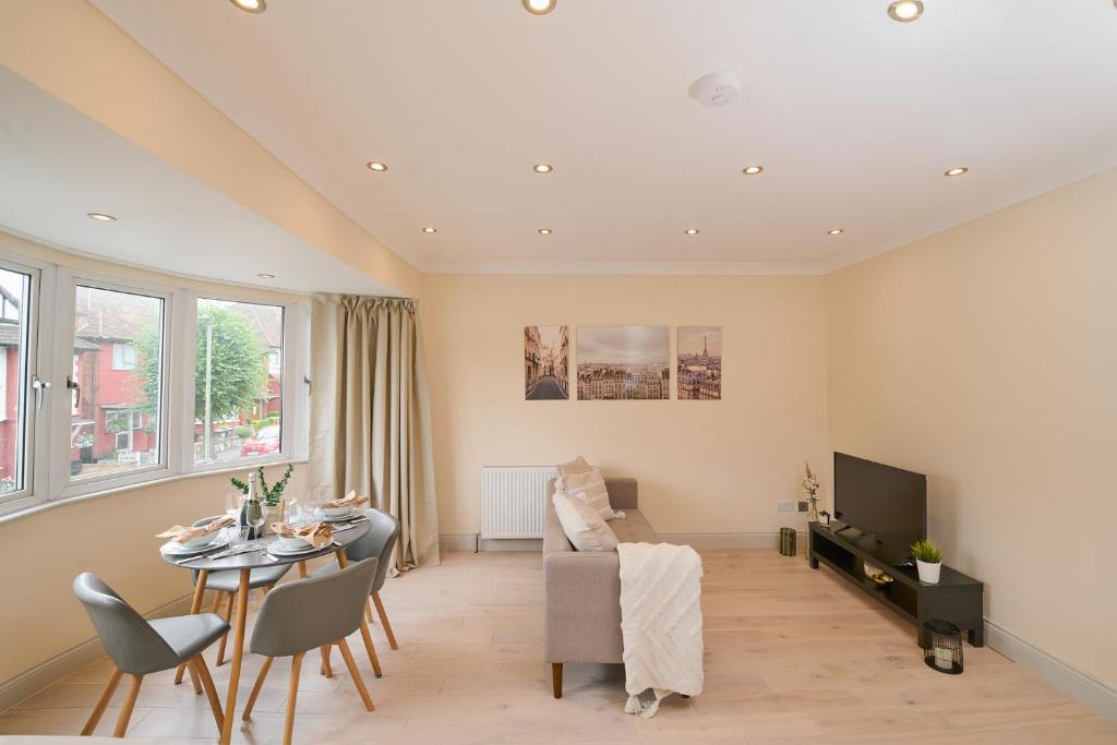 a living room with a table and a dining room at Stylish 4Bed 2 Bath, NW London Large Apartment in London