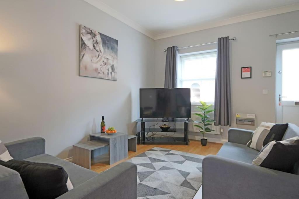 a living room with a couch and a flat screen tv at Deluxe & Modern 2bed House in Derby