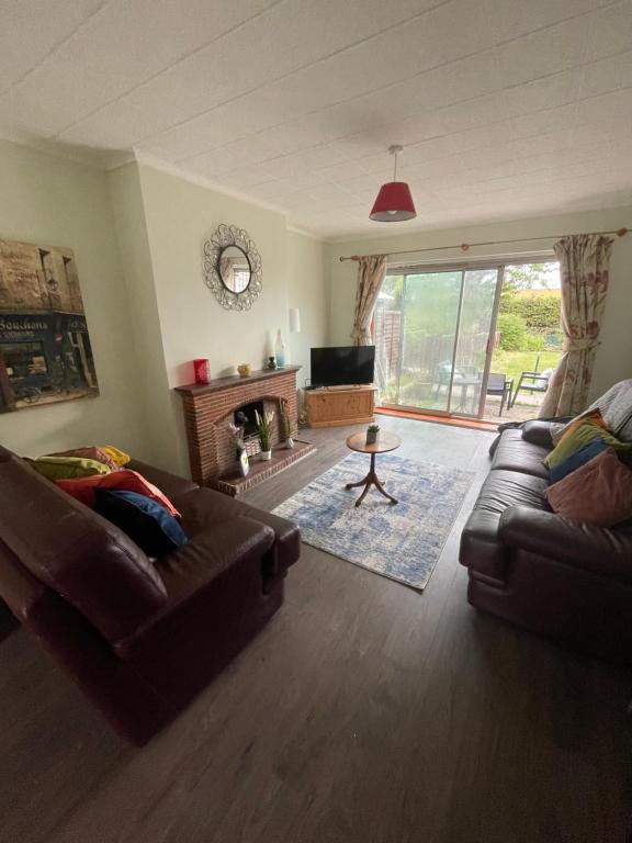 a living room with two couches and a fireplace at Wardown Place - Spacious 3 Bed House available for short term or long term Rental in Luton