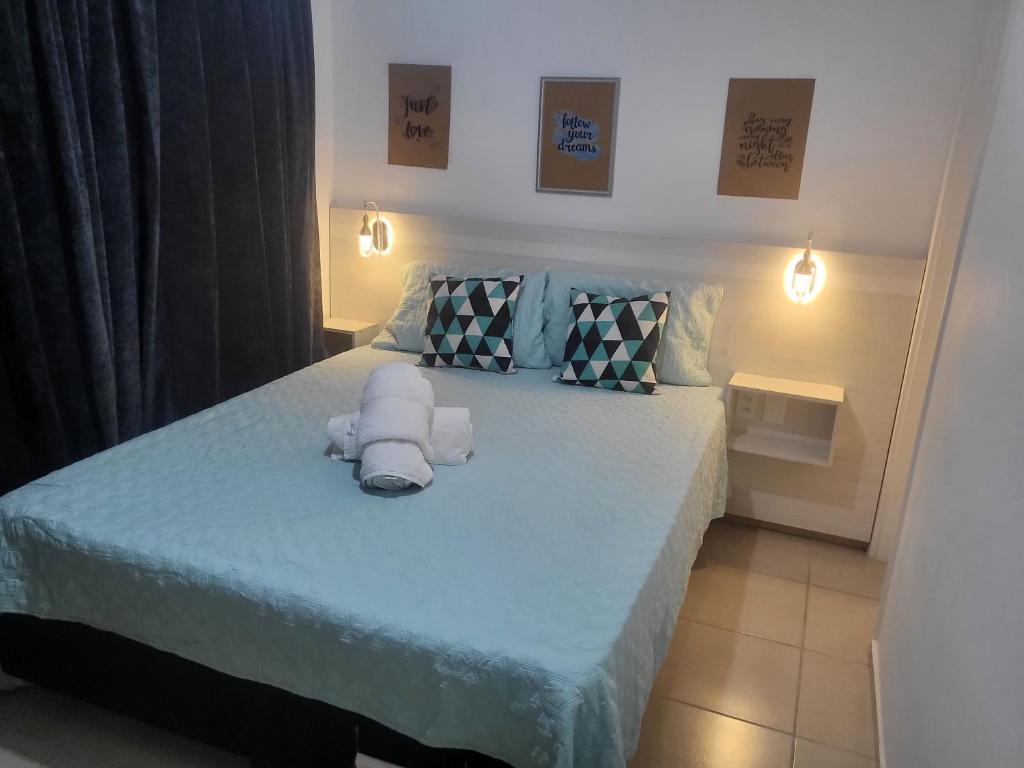 a bedroom with a bed with towels on it at APTO ENCANTADOR, PISCINA, ACADEMIA E MUITO MAIS. in Campo Grande
