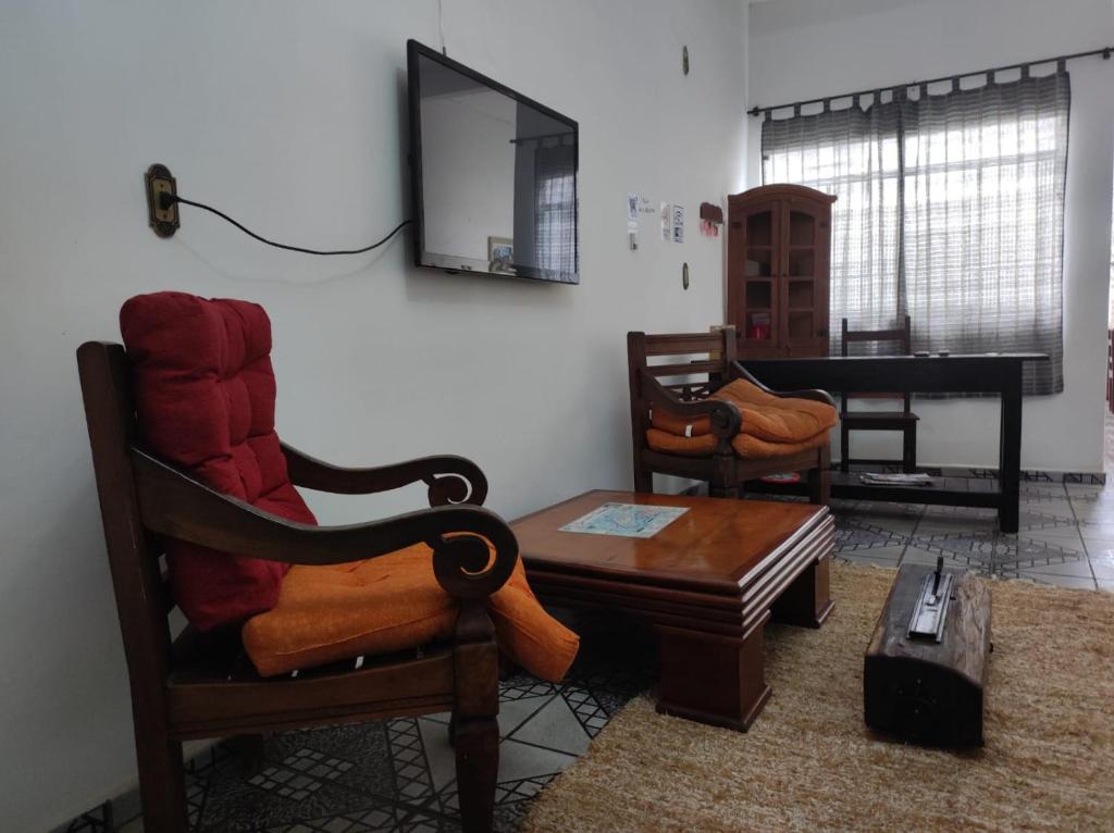sala de estar con sillas, mesa y piano en Pousada Estrada de Ferro en Tiradentes
