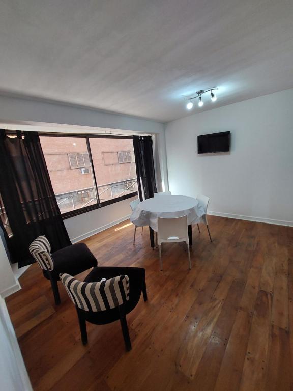 a living room with a table and chairs and a large window at Departamento luminoso pleno centro calle España in Mendoza