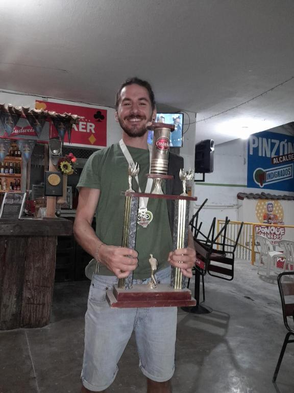 a man is holding a trophy in a store at ADVENTURE Hostel in San Gil