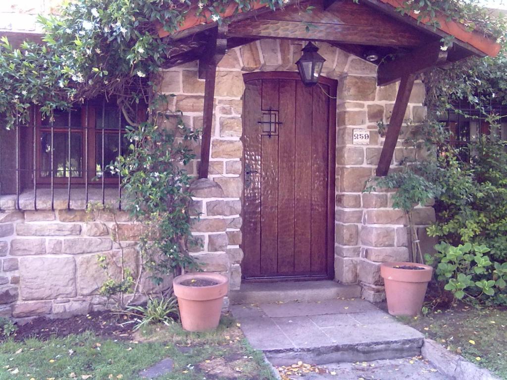 a stone house with a wooden door and plants at Chalet Playa Grande in Mar del Plata