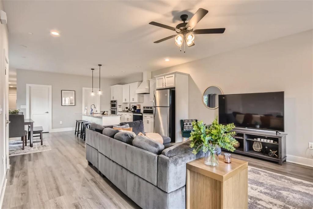 Hotel New Build 5 min to Broadway Sleeps 10, a living room and kitchen with a couch and a ceiling fan at New Build 5 min to Broadway Sleeps 10 in Nashville