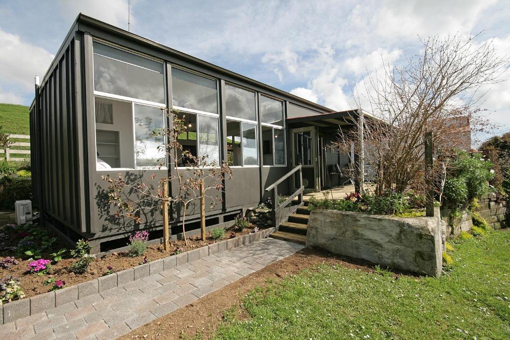 a black house with glass windows on a yard at Bella Park - New Plymouth Holiday Studio in New Plymouth