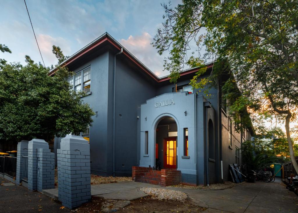 uma casa azul com uma porta laranja em South Yarra Hostel em Melbourne