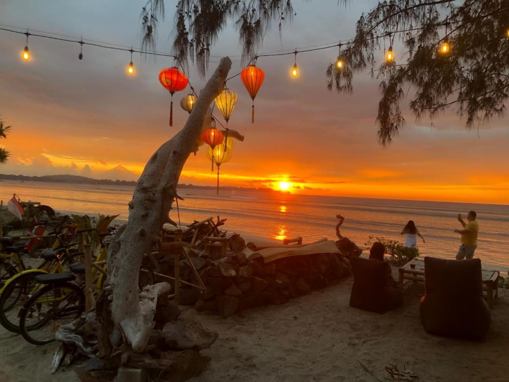 a sunset on the beach with lanterns at La Bohème in Gili Islands