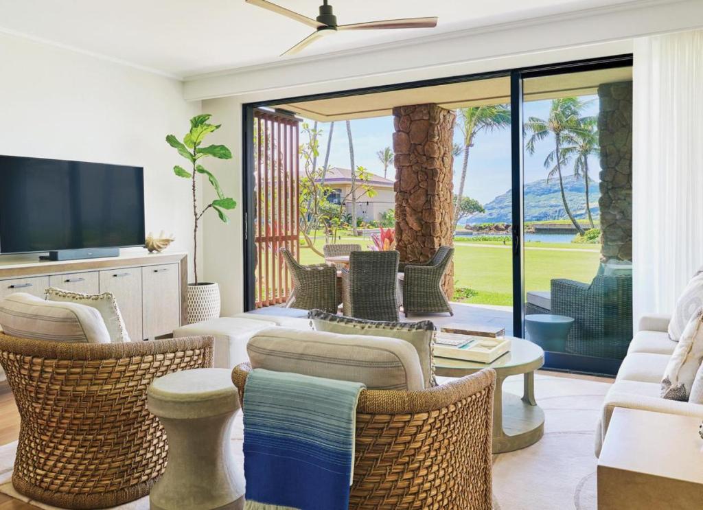 a living room with wicker chairs and a television at Timbers Kaua'i in Lihue