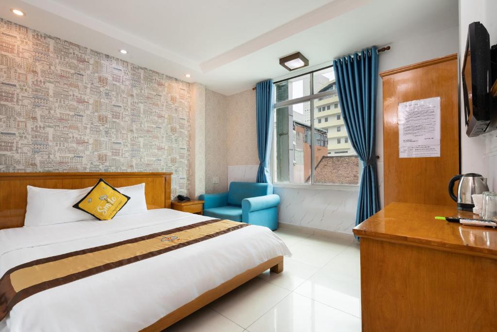 a bedroom with a bed and a chair and a window at Janus Hotel 168 in Ho Chi Minh City