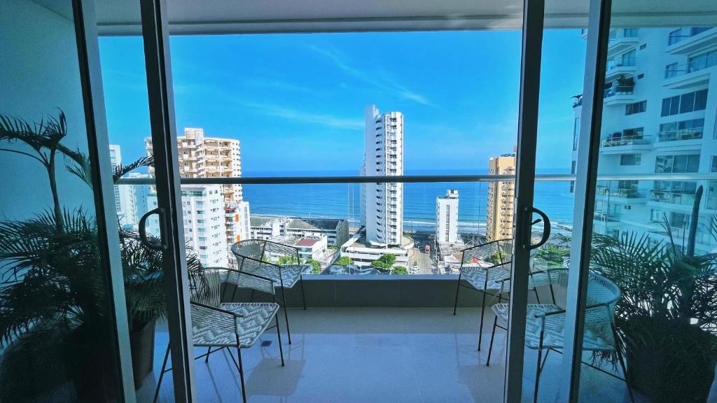 einen Balkon mit Stühlen und Stadtblick in der Unterkunft Cartagena Seaview Elegance in Cartagena de Indias