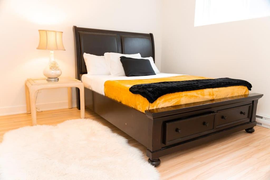 a bedroom with a bed with a black and yellow blanket at Bienvenue chez vous! in Pointe-Calumet