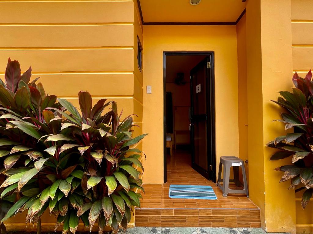 korytarz budynku z żółtymi ścianami i roślinami w obiekcie GOLDEN SUNSET INN w mieście Siquijor