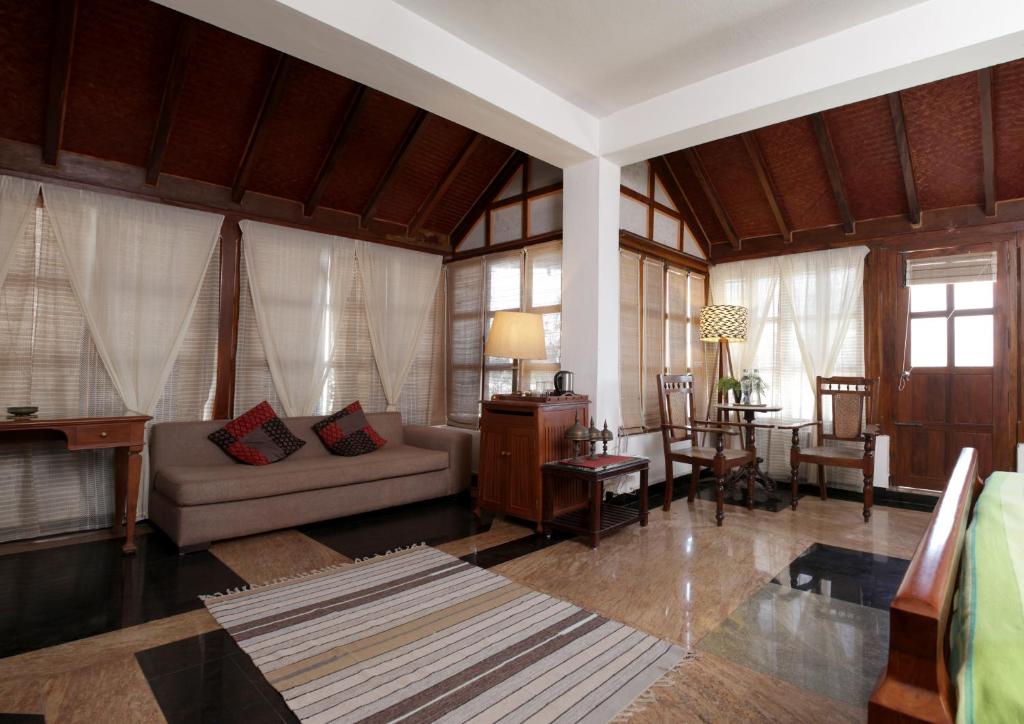 uma sala de estar com um sofá e uma mesa em La Maison de Bitasta em Pondicherry