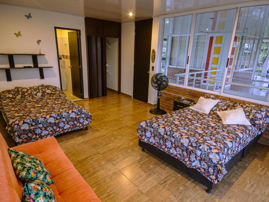 ein Wohnzimmer mit 2 Betten und einem Sofa in der Unterkunft Alojamiento Rural Entre El llano y la selva in San José del Guaviare