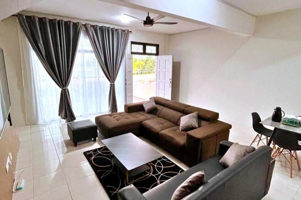 a living room with a couch and a table at Suria Villa @ 5 mins A'famosa Resort in Kampong Alor Gajah