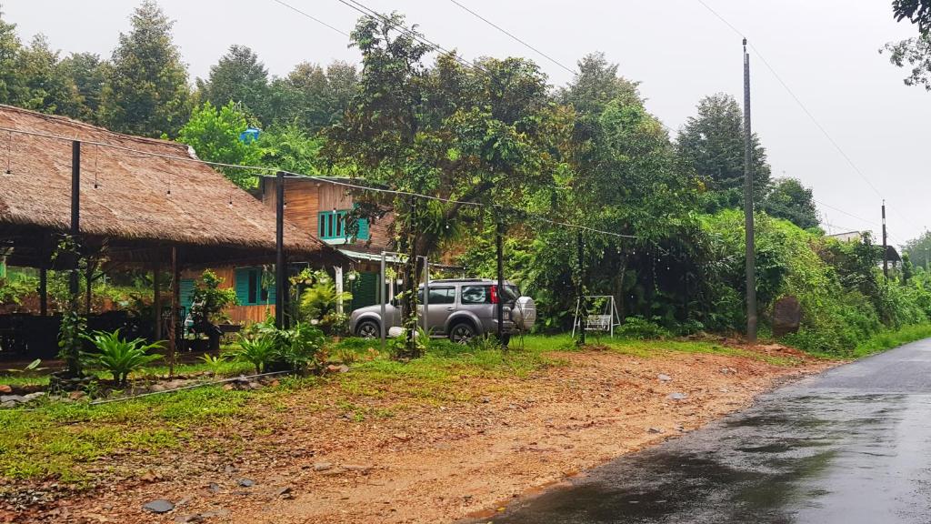 un camión estacionado al lado de una casa al lado de una carretera en Nhà nghỉ đèo Tà Pứa 