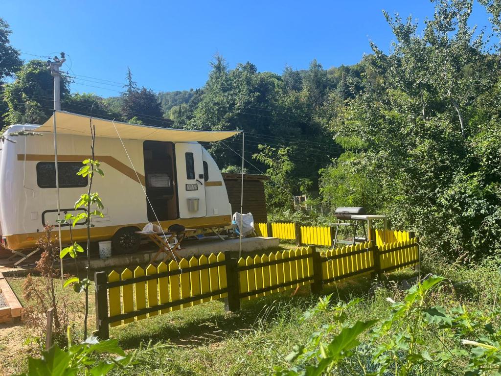 a rv parked behind a yellow fence at Premium Caravan in Sapanca