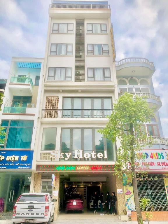 a large white building with people standing outside of it at Sky hotel 390 QUang Trung Thành phố Uông Bí tỉnh Quảng Ninh in Uông Bí