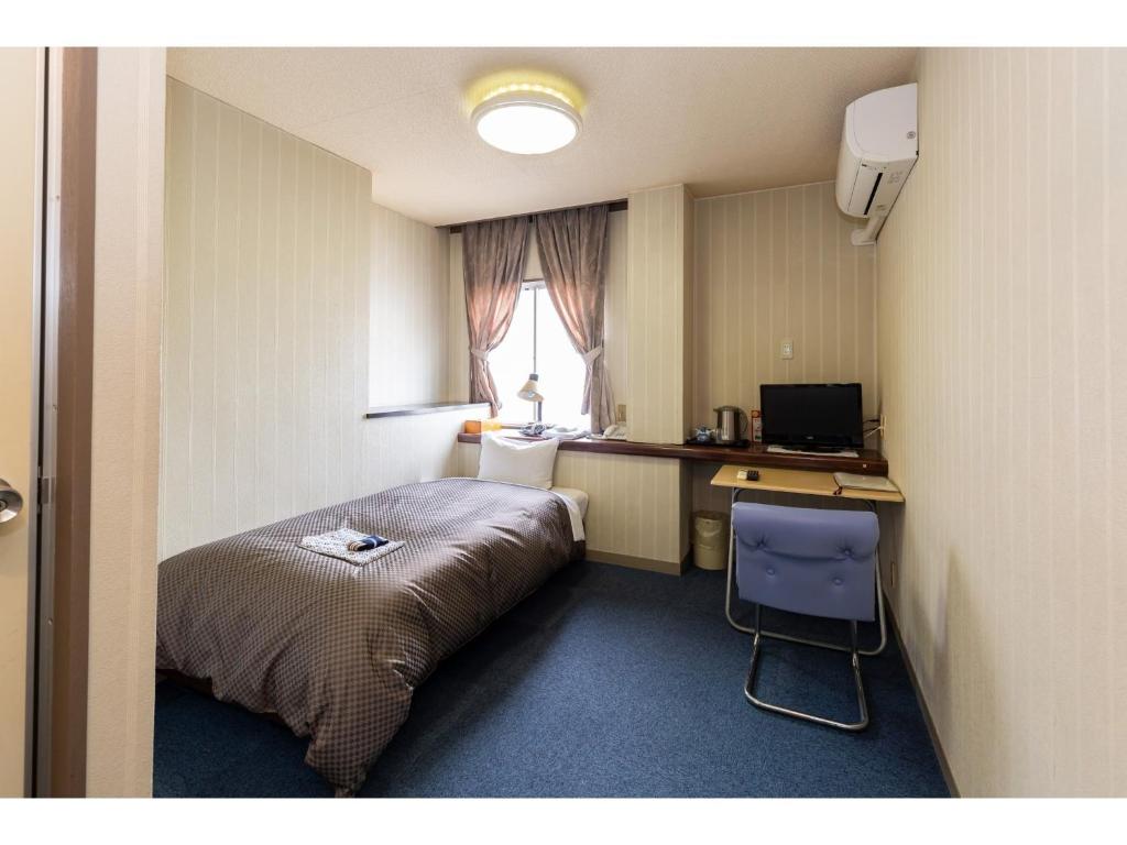 a bedroom with a bed and a desk and a window at Business Hotel Katsuya - Vacation STAY 62197v in Wakayama