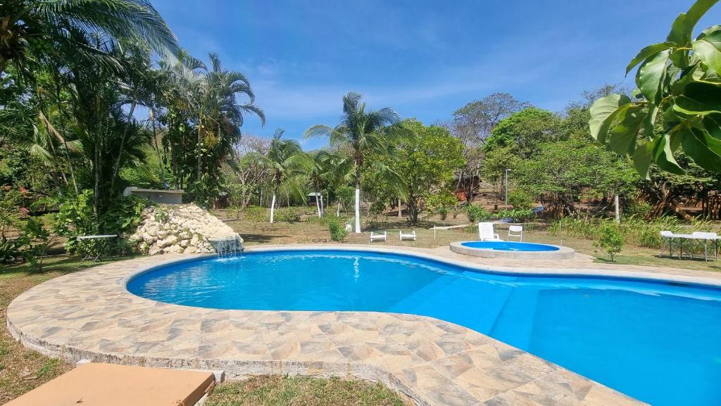 una gran piscina en un patio con árboles en Hotel Hacienda Angeles, en Paraíso