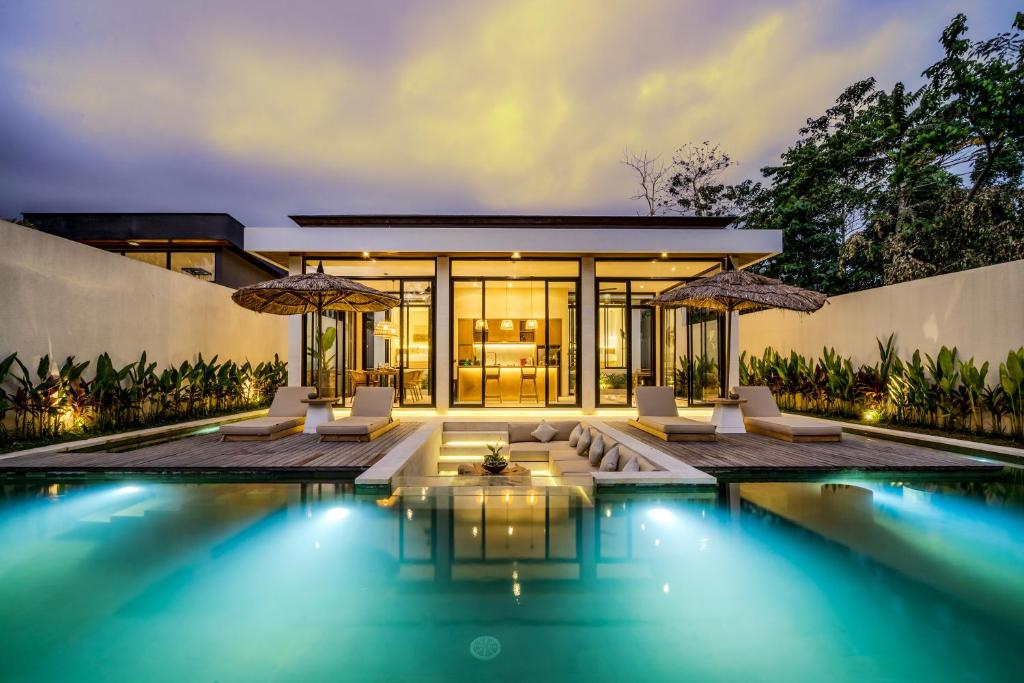 a villa with a swimming pool at night at Villa Elma by BaliSuperHost in Ubud