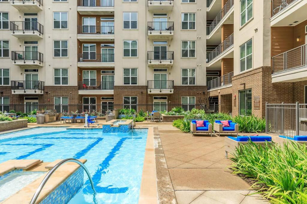 an outdoor pool with chairs and a large apartment building at Downtown Houston Gem: Parking Pool WiFi Sleeps 4 in Houston
