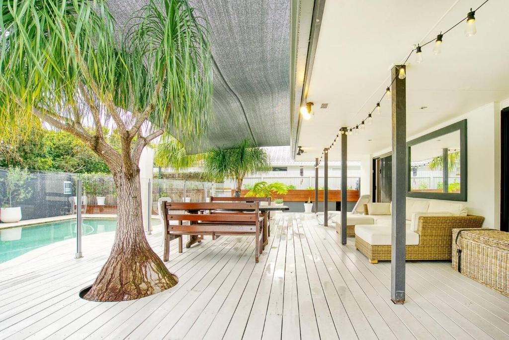una casa con una palma e una piscina di Sunny Days Poolside at an Entertainer's Oasis a Gold Coast