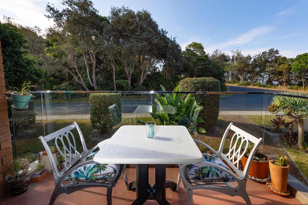 a white table and two chairs on a patio at Oceancrest 4 in Forster
