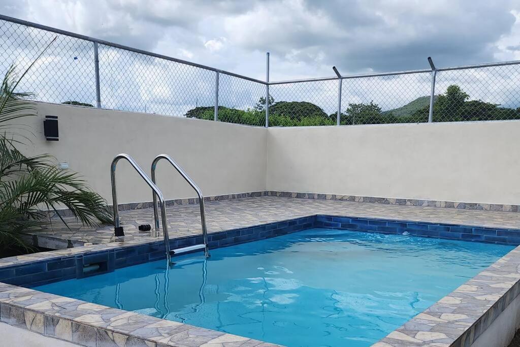 einen Pool mit einer weißen Wand und einem Zaun in der Unterkunft Estrella de Mar Home in Jobos
