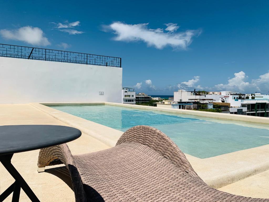 een patio met een tafel en stoelen naast een zwembad bij Rentas Vacacionales Torre Diez in Playa del Carmen