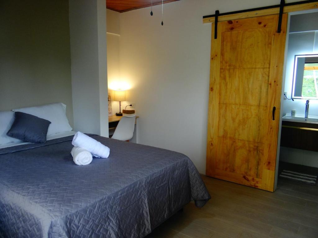 1 dormitorio con 1 cama y puerta de madera en Airport Green Studio, en Santiago Este