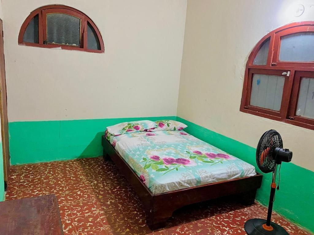 a small bed in a room with a fan at Rainbow House in León