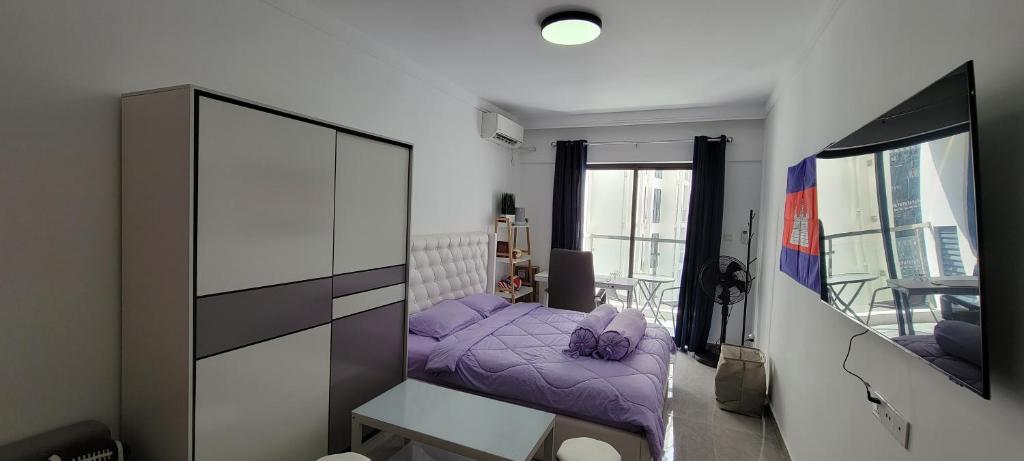 a small bedroom with a purple bed and a mirror at Cozy and Beautiful Condo on Riverside Phnom Penh in Phnom Penh